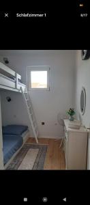 Cette chambre comprend un lit superposé avec une échelle et un bureau. dans l'établissement Etagenwohnung Apartment Sara, à Novi Vinodolski