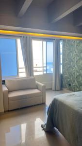 a bedroom with a bed and a couch and windows at Hospedaje,Cartagena,Clasicos,Turismocolombia-fit in Cartagena de Indias