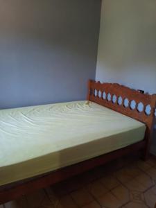 a wooden bed in a room with at Pé na roça in Camanducaia