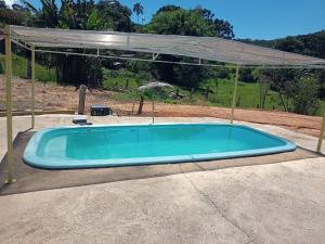 a swimming pool with a canopy and an outdoor swimming poolvisor at Pé na roça in Camanducaia