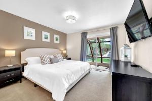 a bedroom with a large bed and a flat screen tv at Reno Retreat-Near Downtown-UNR-Family Fun in Reno