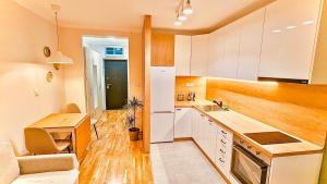 a kitchen with white cabinets and a wooden floor at Studio 4 in Pirot