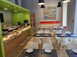 a restaurant with black tables and white chairs and a counter at B40 Green ApartRooms in Budapest