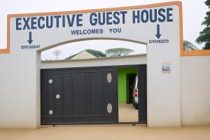 Kyegegwaにあるexecutive guest house bukereの「高級ゲストハウスへようこそ」と書かれた看板が掲げられたガレージのドア