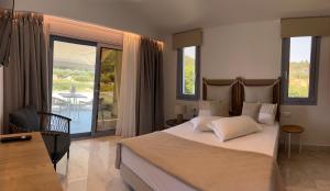 a bedroom with a large bed and a balcony at Notia Luxury Living in Porto Koufo