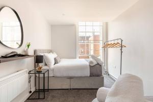 a white bedroom with a bed and a mirror at Spacious 2Bed Central Liverpool Nightlife & Events, sleeps up to 10 in Liverpool