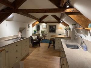 Una cocina con encimeras blancas y techos de madera. en Rawcliffe Barn, 2 Bedroom, up to 4 Guests, en Newton