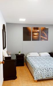 a bedroom with a bed and pictures on the wall at Hospedaje,Cartagena,Clasicos,Turismocolombia-fit in Cartagena de Indias