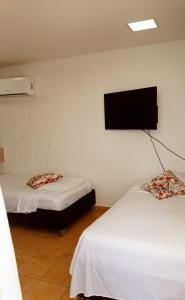 a room with two beds and a flat screen tv at Hospedaje,Cartagena,Clasicos,Turismocolombia-fit in Cartagena de Indias