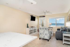 a bedroom with a bed and a couch and a chair at Beach Front Villa - Right On The Beach! in Holmes Beach