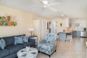 a living room with a couch and a chair and a kitchen at Beach Front Villa - Right On The Beach! in Holmes Beach