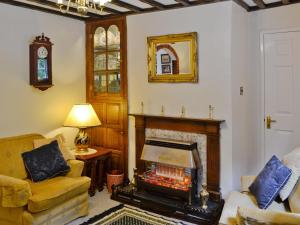 sala de estar con chimenea y espejo en Y Bwthyn, en Bala