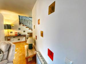 a living room with a white wall with pictures on it at Casa los caminos de GRANADA in Cozvíjar