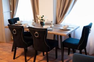 a dining room table with chairs and a wooden table with cups at Cozy Hideaway Your Urban Escape in Craiova