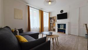 ein Wohnzimmer mit Couch und Kamin in der Unterkunft Le Miel d'Opale - Ferry, Shuttle and Beach in Calais