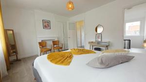 ein Schlafzimmer mit einem großen weißen Bett mit zwei Kissen in der Unterkunft Le Miel d'Opale - Ferry, Shuttle and Beach in Calais