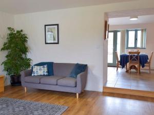 una sala de estar con un sofá y una mesa en West Barn - Uk31850, en Trecwn