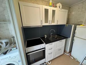 a small kitchen with a sink and a stove at Small apartment in Elnesvågen in Svinøya