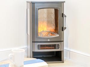 an oven with a fire inside of it at Ty Draenog - Uk31653 in New Quay