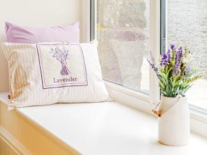 a window sill with two pillows and a vase of flowers at Ty Draenog - Uk31653 in New Quay
