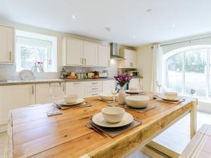 a kitchen with a wooden table with dishes on it at Ty Draenog - Uk31653 in New Quay