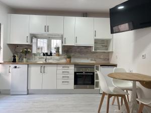 a kitchen with white cabinets and a wooden table at Blue Bay Beach Apartment - Laura in Sesimbra +13 photos
