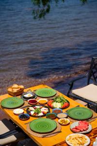 a table with plates of food on it next to the water at Marimare Beach & Bungalow in Marmaris