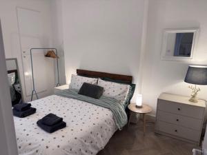 a bedroom with a bed with two black towels on it at Balloch But & Ben in Balloch +1 photo