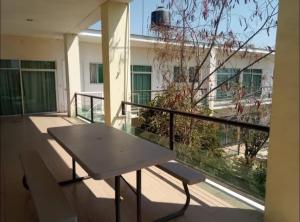 a balcony with a table and a large window at ESTANCIA Santa Teresa in Temixco