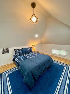 Un dormitorio con una cama grande con un edredón azul. en NYC-Style Loft with Secret Entrance - Just 6 Miles from Times Square, en North Bergen