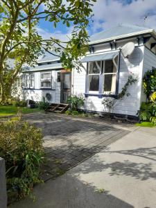 a white house with a driveway in front of it at Great place to stay in Gisborne