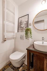 a bathroom with a toilet and a sink and a mirror at Hidden gem in the very heart of the city in Budapest