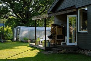 a screened in porch of a house with a chair at Pelēkā Māja, summer house for cosy stays in Myza Brenguli +31 photos