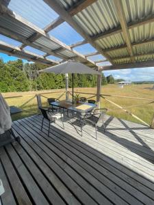 una terraza con mesa, sillas y sombrilla en Cabaña con tinaja, en Puerto Clocker