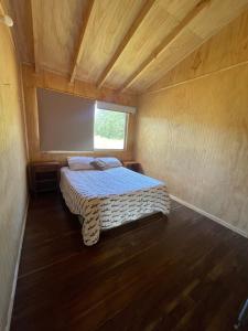 Un dormitorio con una cama en una habitación con ventana. en Cabaña con tinaja, en Puerto Clocker 12 fotos más