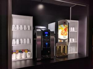 a refrigerator with a drink inside of it with a drink dispenser at Campanile Hôtel Auch in Auch