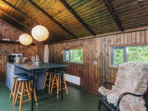 a kitchen with a table and stools in a cabin at 4 person holiday home in Hampen in Hampen