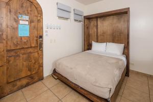 a small bedroom with a bed and a wooden door at Bella Sirena 2BR 2BA 1st FL Spacious Patio B104 in La Choya +53 photos