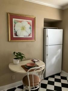 a kitchen with a table and a white refrigerator at Private Lafayette Getaway Balcony & Kitchen in Lafayette +12 photos