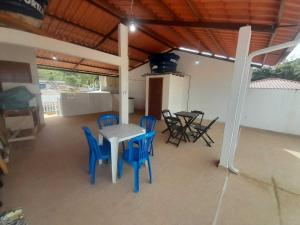 a patio with blue chairs and a table and a table and chairs at Flat novo 06 a pé Prainha de Mambucaba Paraty RJ in Paraty