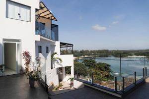 a white house with a view of the water at Suítes Luxo Marambaia- Epic House in Rio de Janeiro