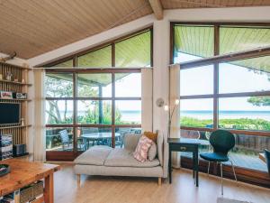 a living room with a couch and a table and windows at 4 person holiday home in Glesborg in Glesborg