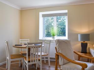 ein Esszimmer mit Tisch und Stühlen und einem Fenster in der Unterkunft Swallow Cottage in Gowerton