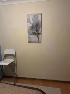 a painting on a white wall with a chair at Home Sweet Home in Moffat