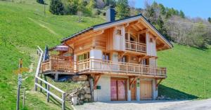 a log cabin on a hillside with a porch at Gite Les Tarines 1 in Beaufort