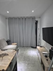 a living room with a couch and a flat screen tv at Appartement avec terrasse in Vias