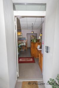 an open door to a kitchen with a red rug at Hotel Kapa Gorry in Saint-Jean-de-Luz