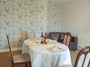 a dining room with a table with a white table cloth at Brick Cottage 2-Uk13675 in Palnure