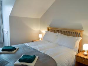 a bedroom with a bed with two towels on it at Brick Cottage 2-Uk13675 in Palnure