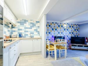 a kitchen with a table and a tv on a wall at Awel Y Mor Sea Breeze in Cemaes Bay